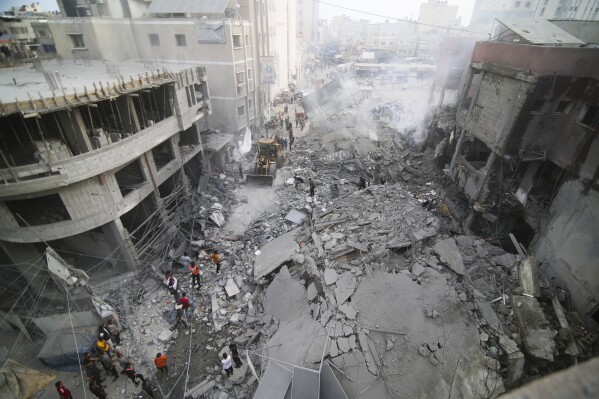 Palestinians inspect the damage of destroyed building after Israeli airstrikes in Khan Younis, Gaza Strip, Tuesday, Oct. 10, 2023. (AP Photo/Hatem Ali)